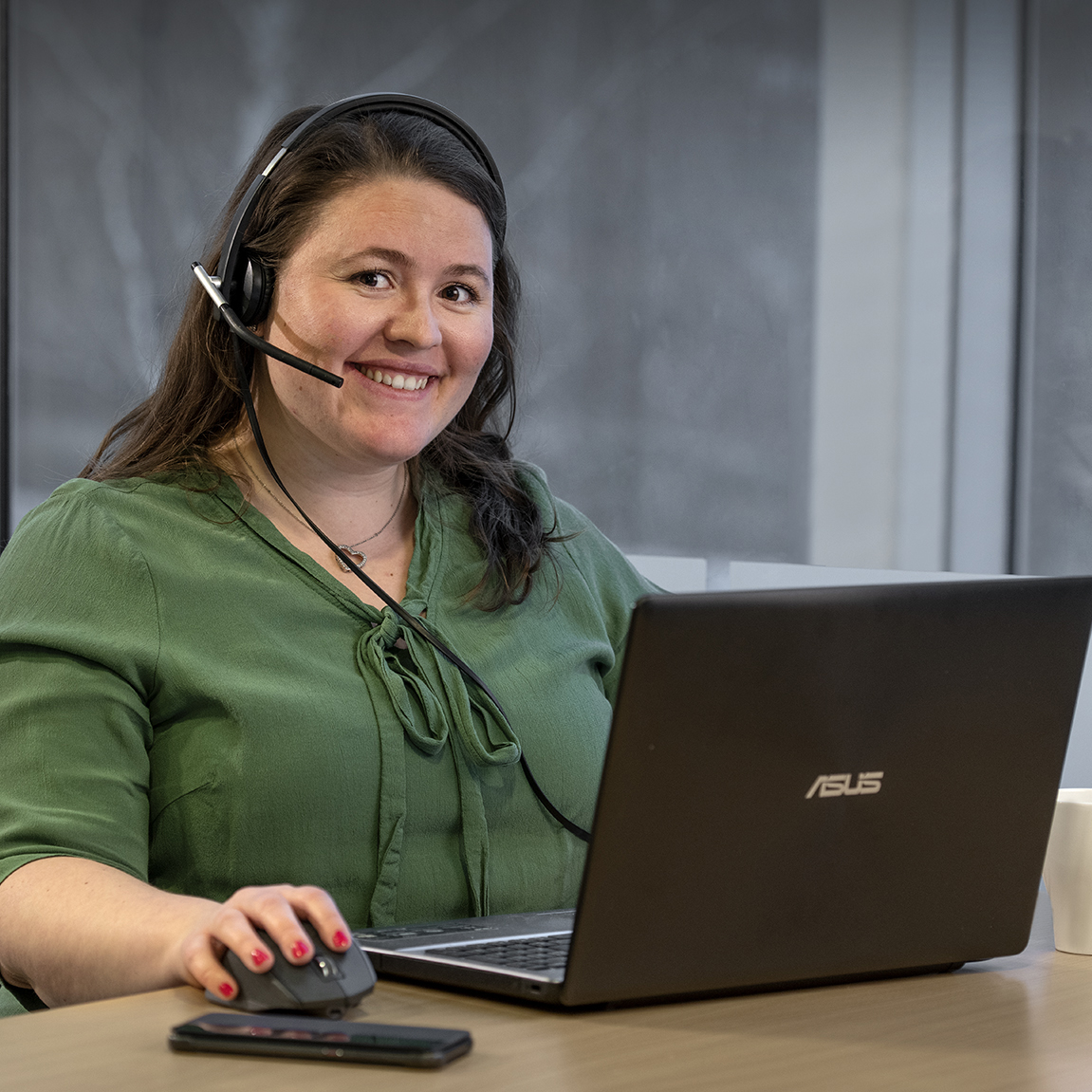 Kvinne ved laptop med headset klar for å yte support