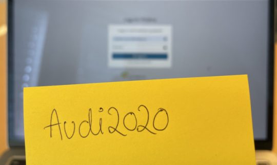 Enkelt passord på en postit lapp foran et innloggingsvindu på en laptop