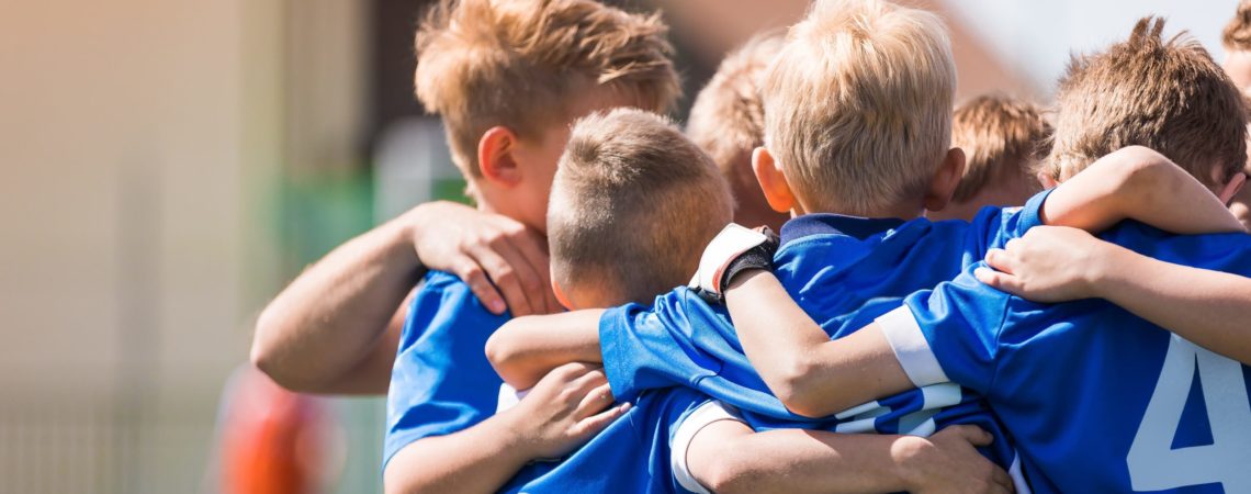 Fotballlag med gutter står sammen