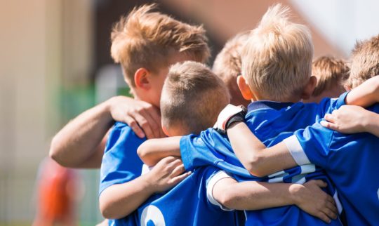 Fotballlag med gutter står sammen